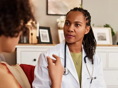 Ärztin unterhält sich mit Patientin über Husten.