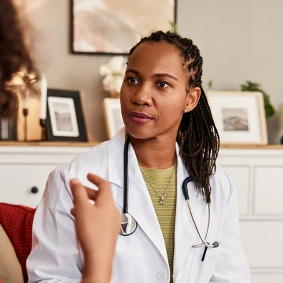 Ärztin unterhält sich mit Patientin über Husten.