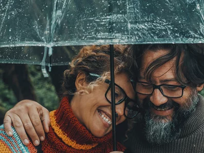 Frau und Mann im Herbst unter einem Regenschirm.