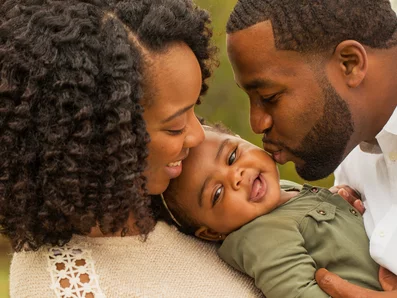 Wenn Babys oder Säuglinge* husten , möchte man als Eltern schnell helfen. Glücklicher Mann und Frau mit lachendem Baby im Arm.