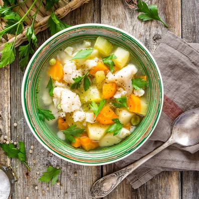 Gemüsebrühe mit Gemüsestücken in einer Schüssel.